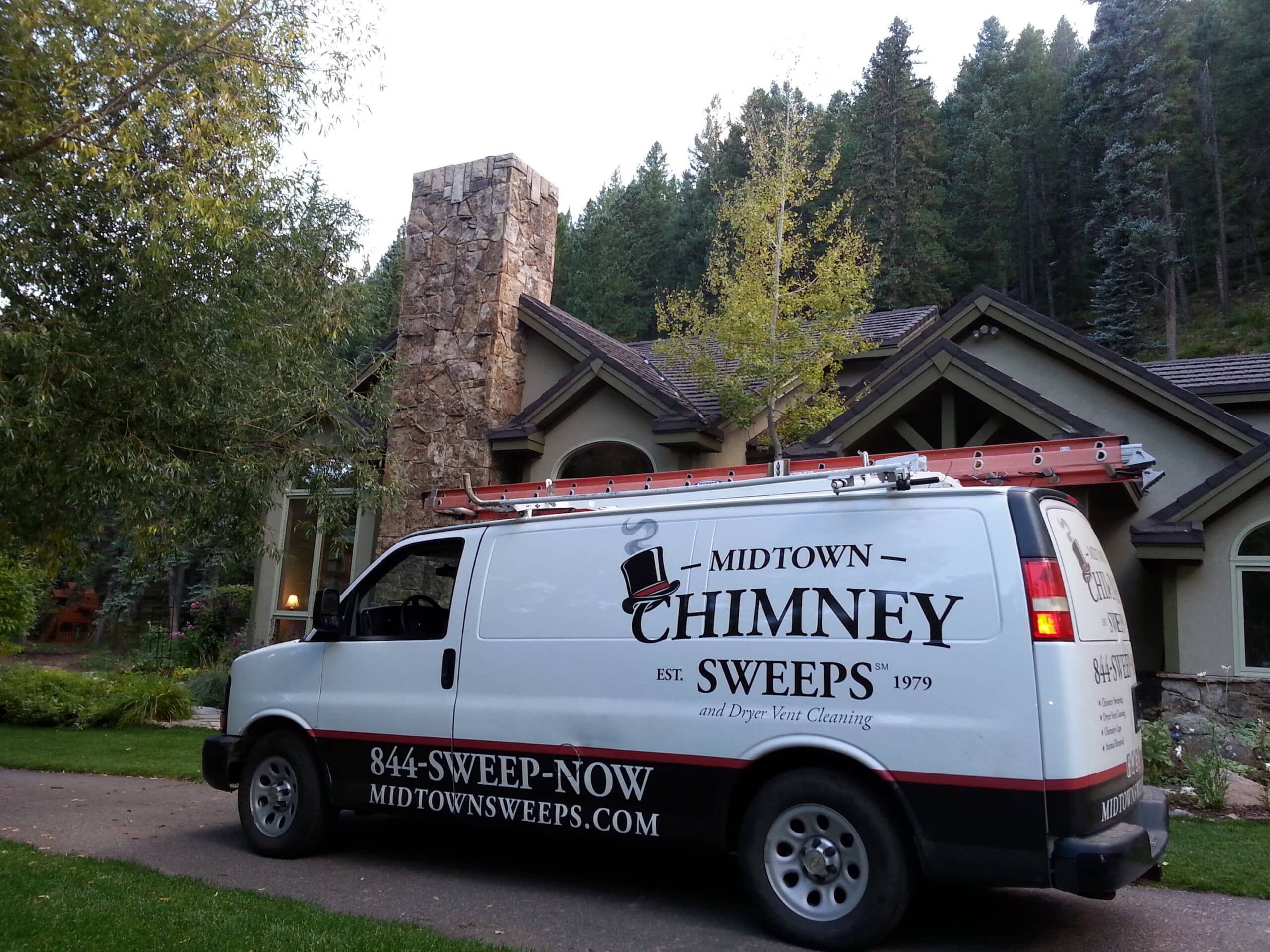 Midtown Chimney Services service van parked in front of a stone home