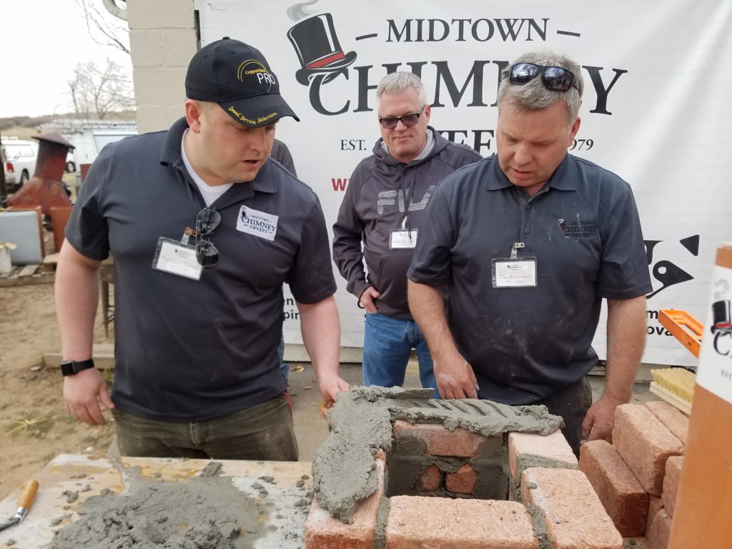 Midtown franchise trainees building a brick firebox