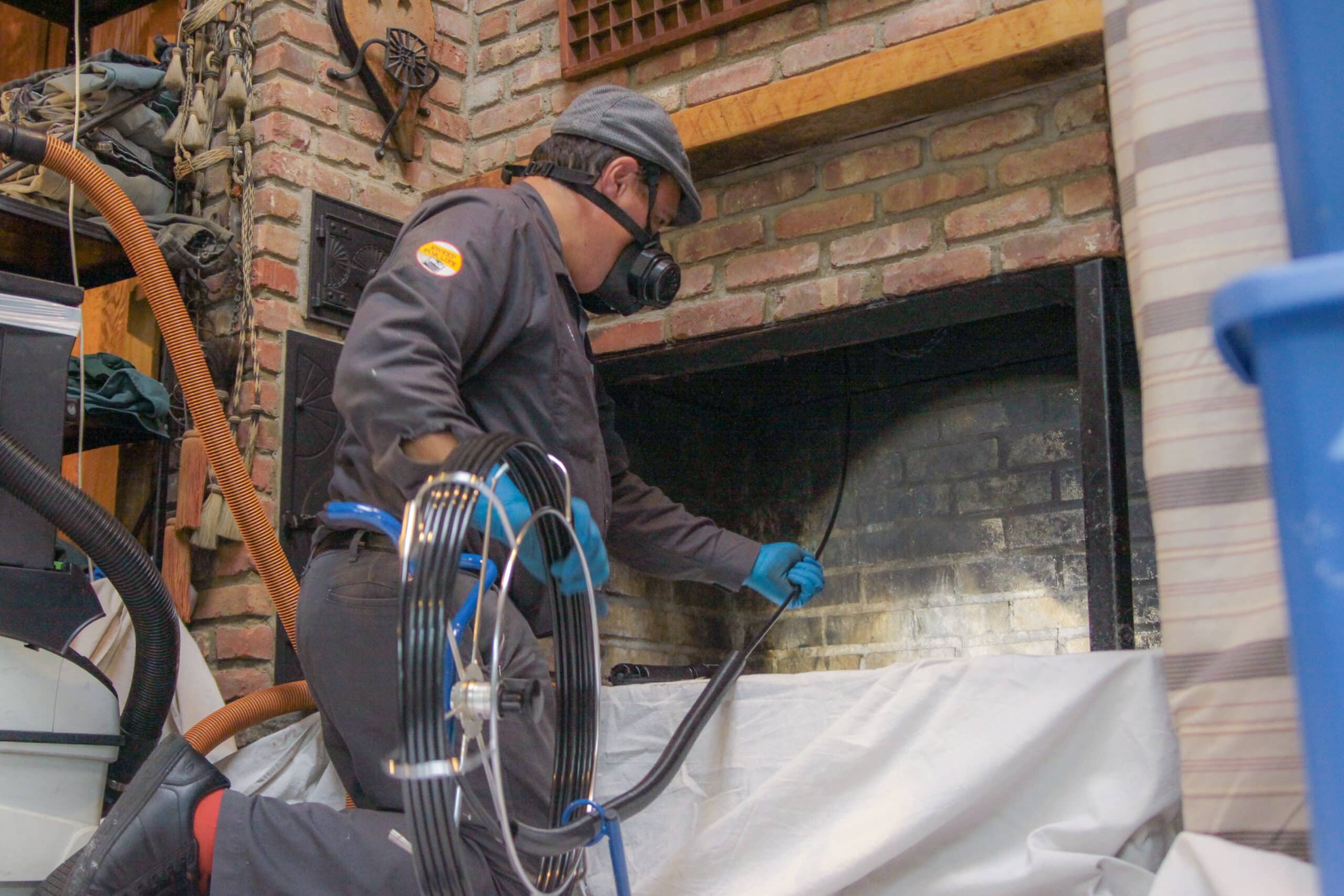 Midtown technician sweeping a brick fireplace with rotary equipment
