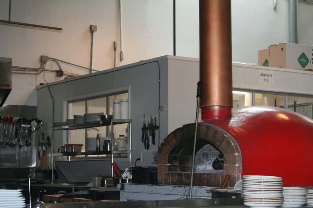 Red wood-burning stove installed on a stone hearth